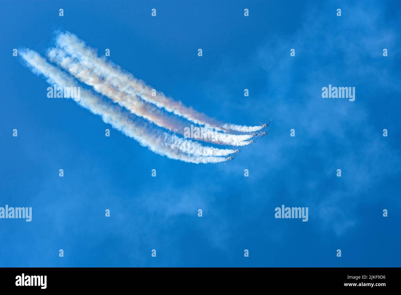 Los cazas se lanzan en el cielo dejando un denso rastro de humo Foto de stock