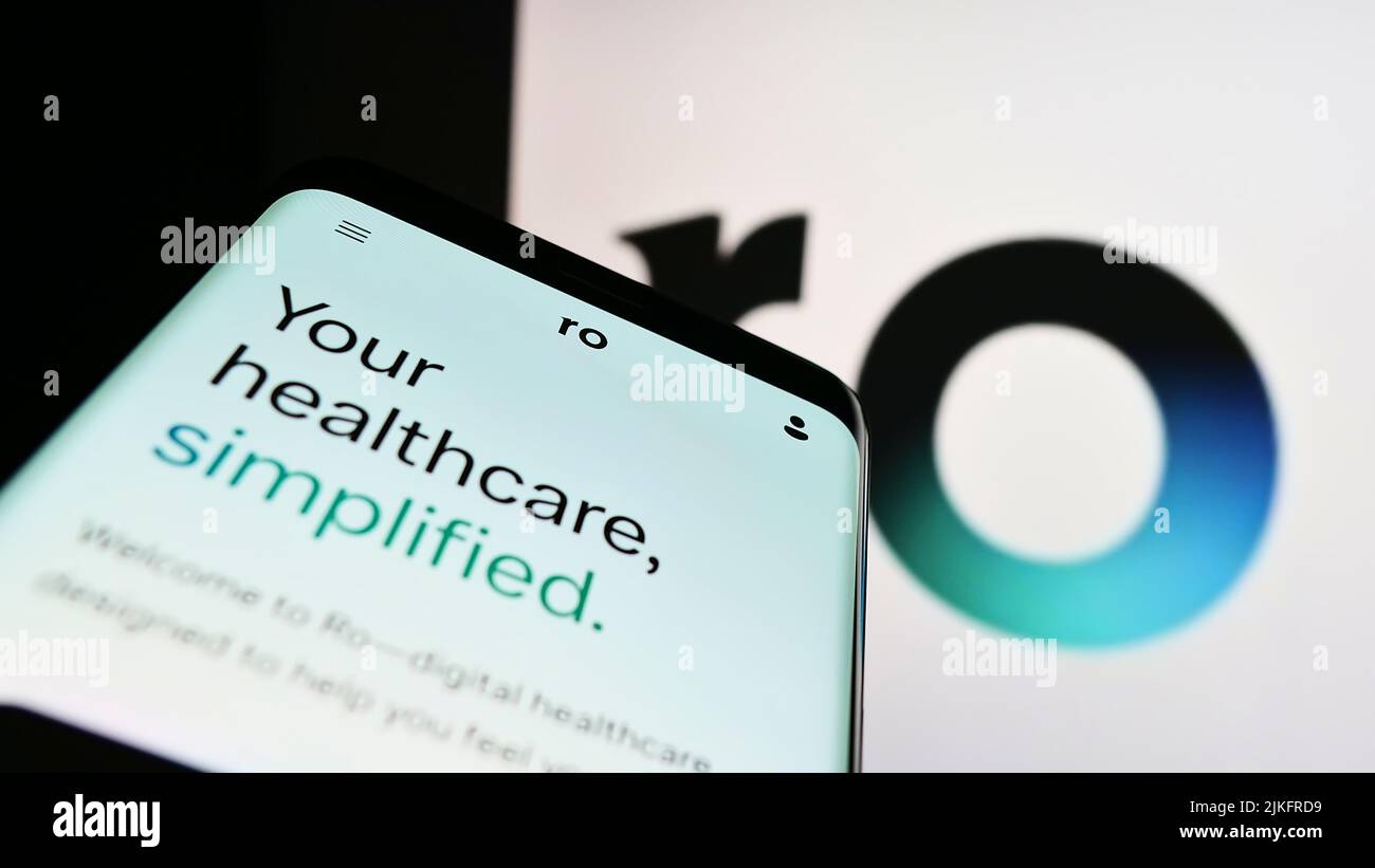 Smartphone con sitio web de la empresa de telesalud Roman Health Ventures Inc. (RO) en la pantalla delante del logotipo. Enfoque en la parte superior izquierda de la pantalla del teléfono. Foto de stock