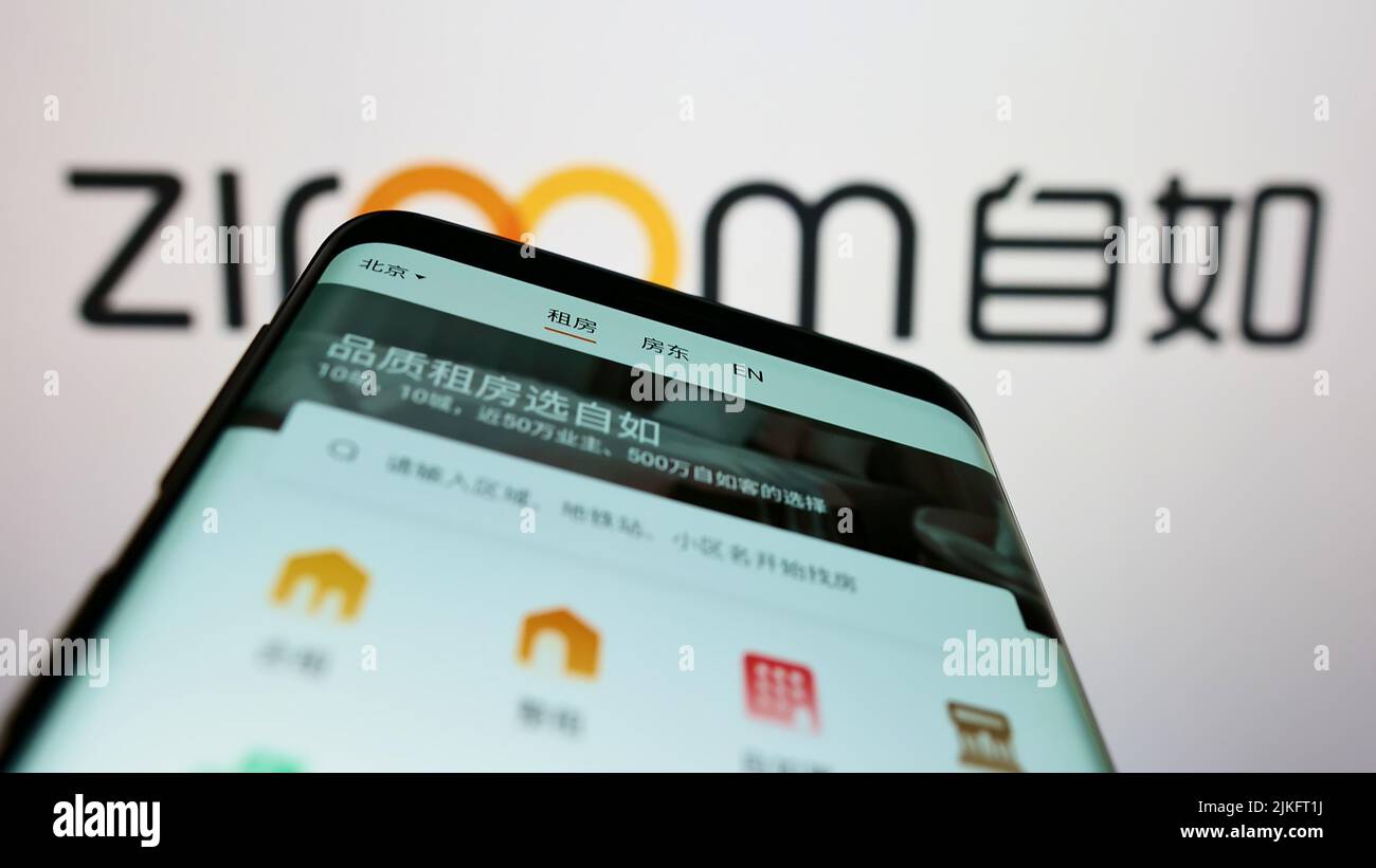 Teléfono móvil con el sitio web de la inmobiliaria china Ziroom en la pantalla delante del logotipo del negocio. Enfoque en la parte superior izquierda de la pantalla del teléfono. Foto de stock