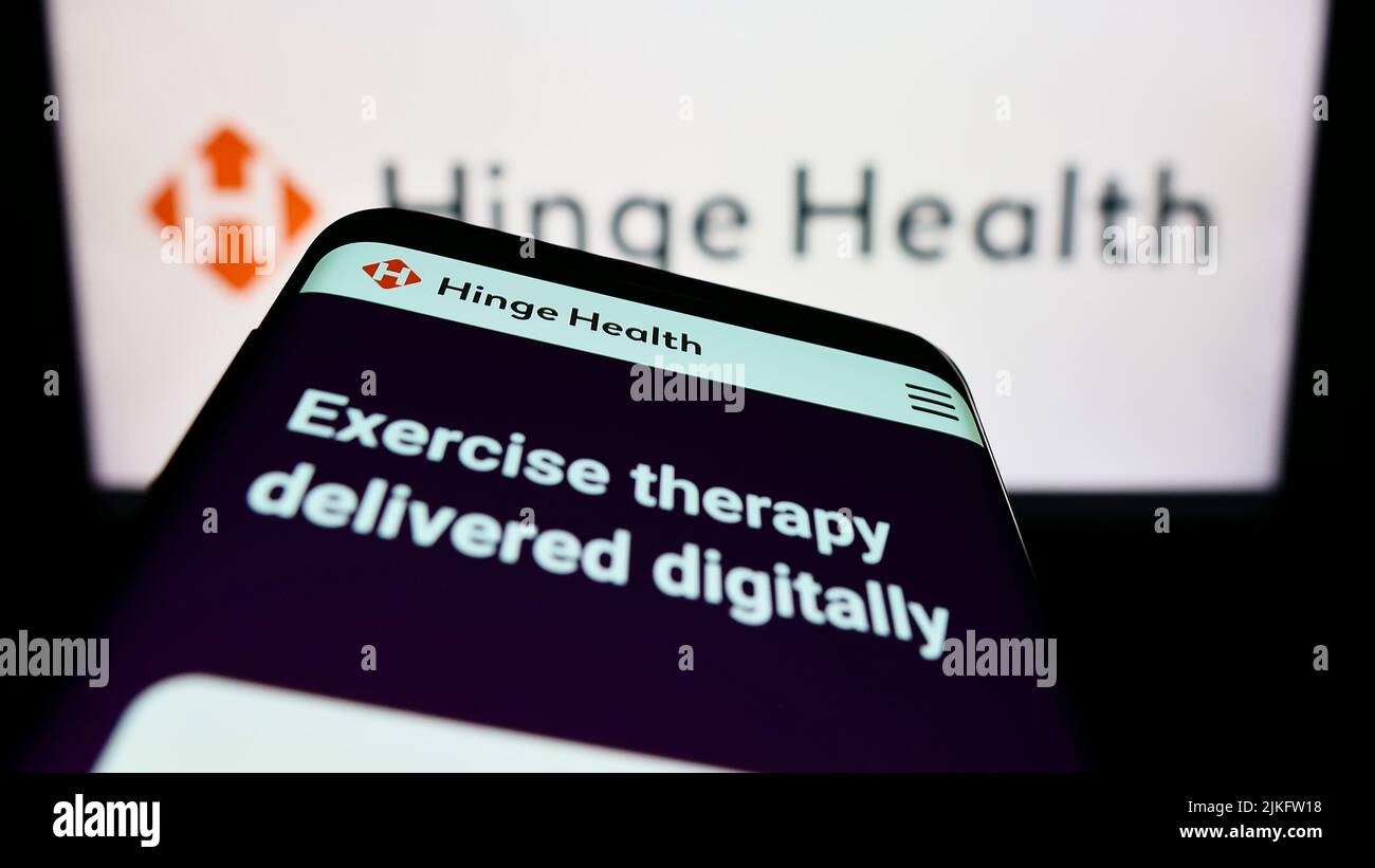 Teléfono móvil con sitio web de la empresa estadounidense de clínica digital Bisagra Health Inc. En la pantalla delante del logotipo del negocio. Enfoque en la parte superior izquierda de la pantalla del teléfono. Foto de stock