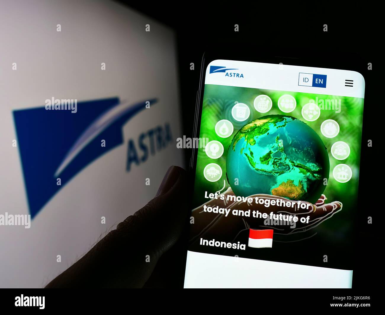 Persona que sostiene el celular con el Web site de la compañía indonesia PT Astra International Tbk en la pantalla con el logo. Enfoque en el centro de la pantalla del teléfono. Foto de stock