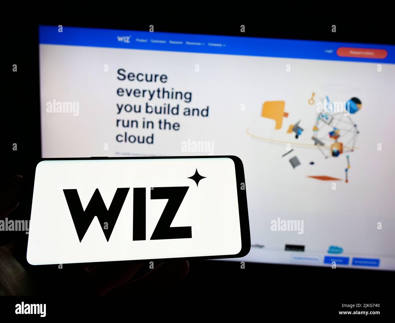 Persona que sostiene el teléfono móvil con el logotipo de la compañía de seguridad en la nube de EE.UU. Wiz Inc. En la pantalla delante de la página web del negocio. Enfoque la pantalla del teléfono. Foto de stock