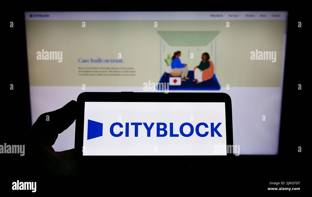 Persona con smartphone con el logotipo de la empresa de asistencia sanitaria estadounidense CityBlock Health Inc. En la pantalla delante del sitio web. Enfoque la pantalla del teléfono. Foto de stock