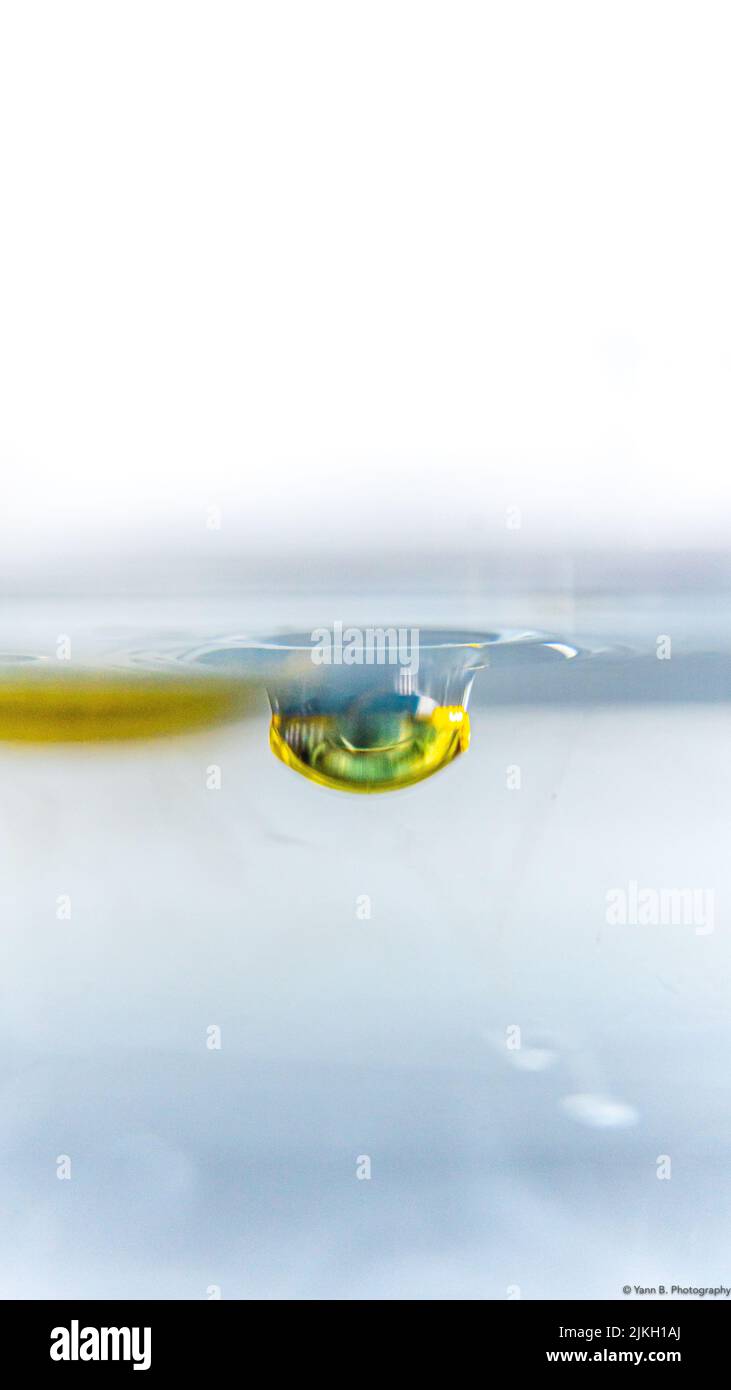 Un primer plano vertical de una gota de aceite en el agua Foto de stock