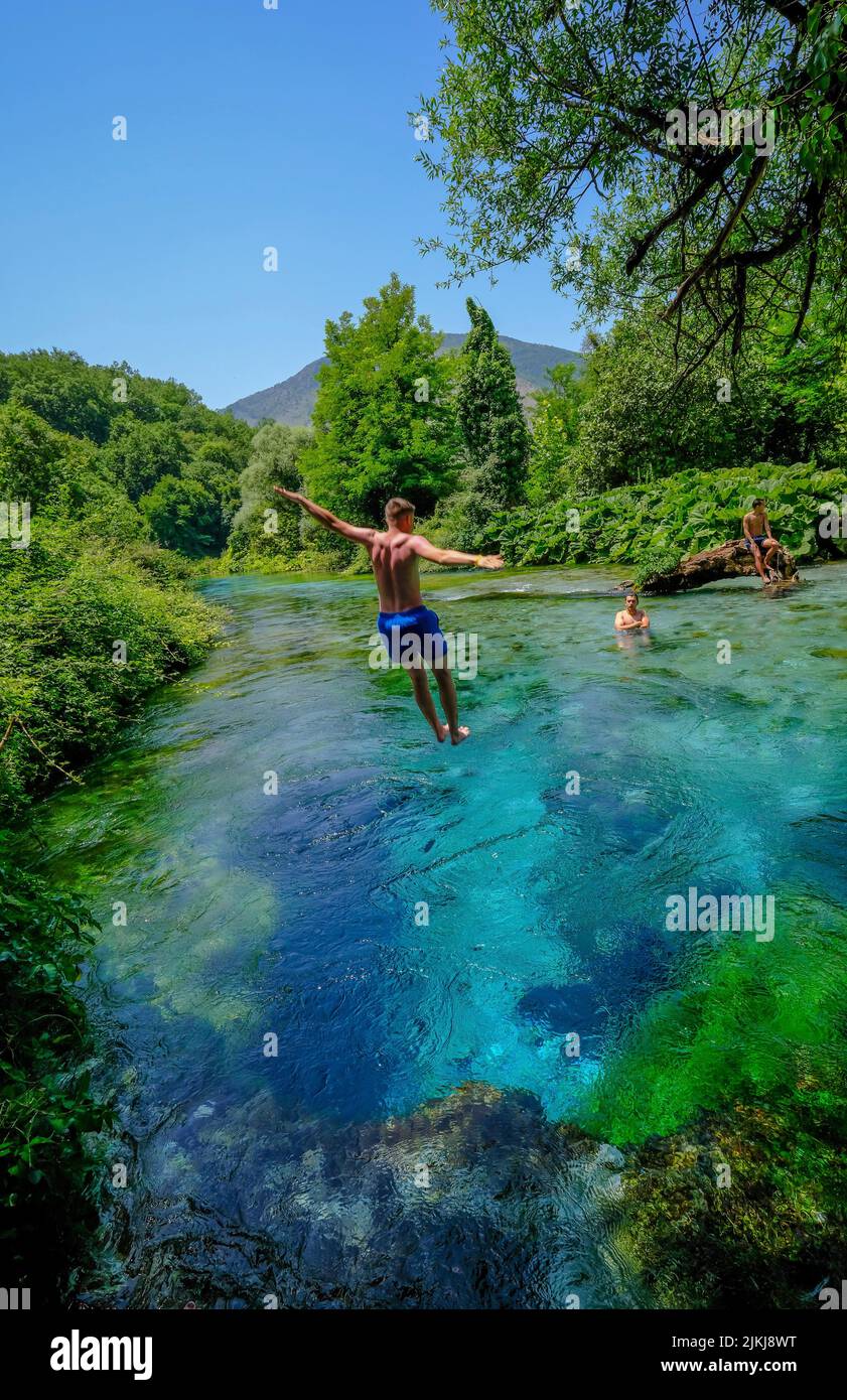 Muzina, Albania - Los turistas se bañan en Syri i Kaltër, EL OJO AZUL es la fuente de agua más abundante del país con 6 ö³/s, situada a medio camino entre las ciudades más grandes de Saranda en la costa y Gjirokastra tierra adentro. Foto de stock