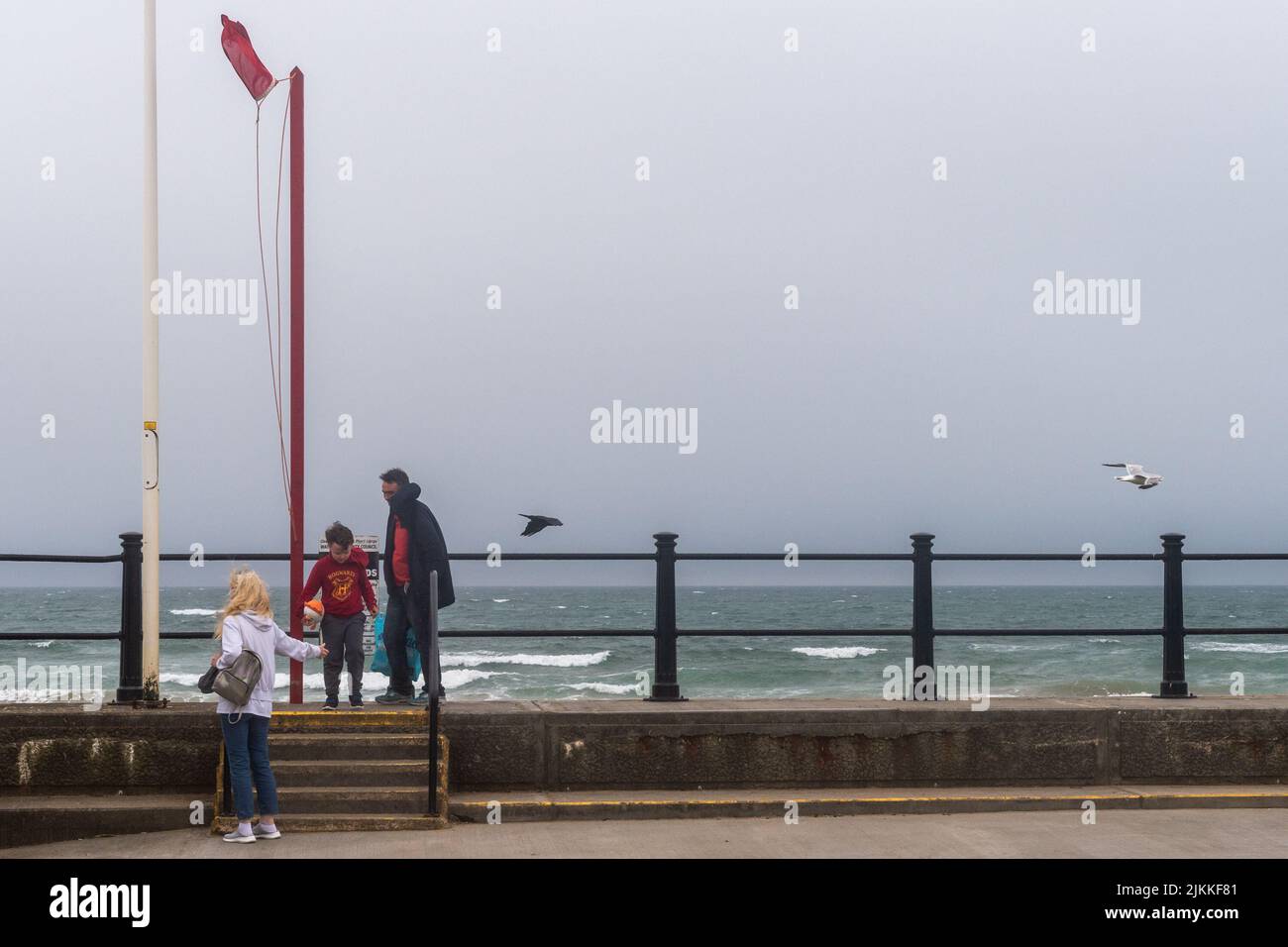 Tramore, Co. Waterford, Irlanda. 2nd de Ago de 2022. Los vientos de fuerza Gale golpean Tramore hoy con las banderas rojas volando en la playa y sólo los diehards en el agua. Met Éireann ha pronosticado el sol y las temperaturas cálidas para los próximos dos días. Crédito: AG News/Alamy Live News Foto de stock