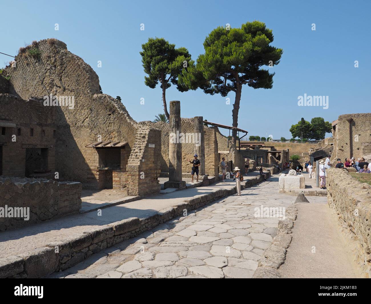 Tousiste en una calle en Herculano, una ciudad romana que también fue cubierta por la erupción del Vesubio en el anuncio de 79. Es más pequeño que Pompeya, pero fue dañado Foto de stock