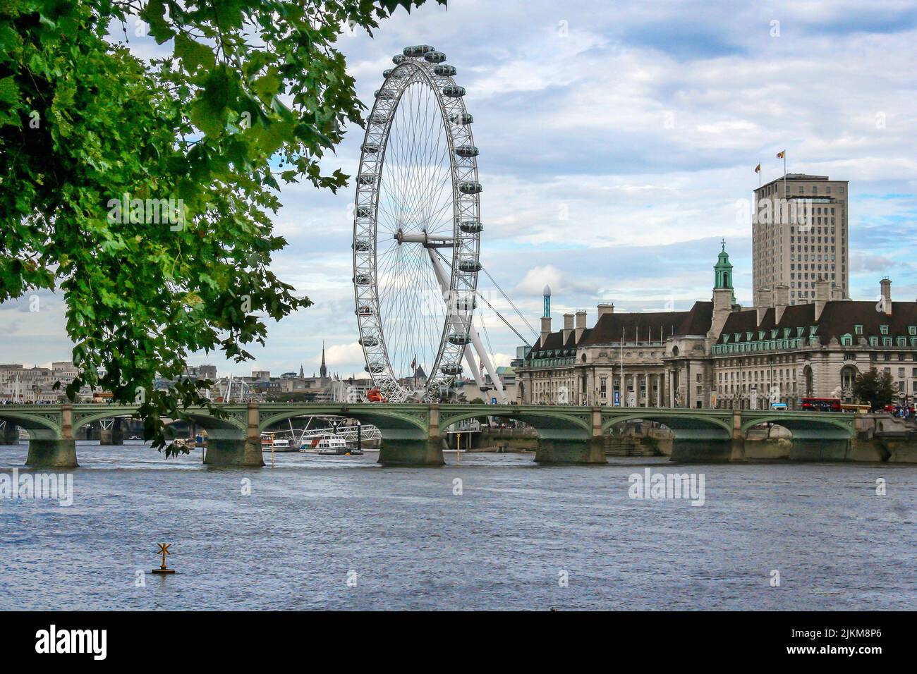 Una hermosa escena de las norias London Eye en Londres, el Reino Unido, con un cielo azul nublado Foto de stock