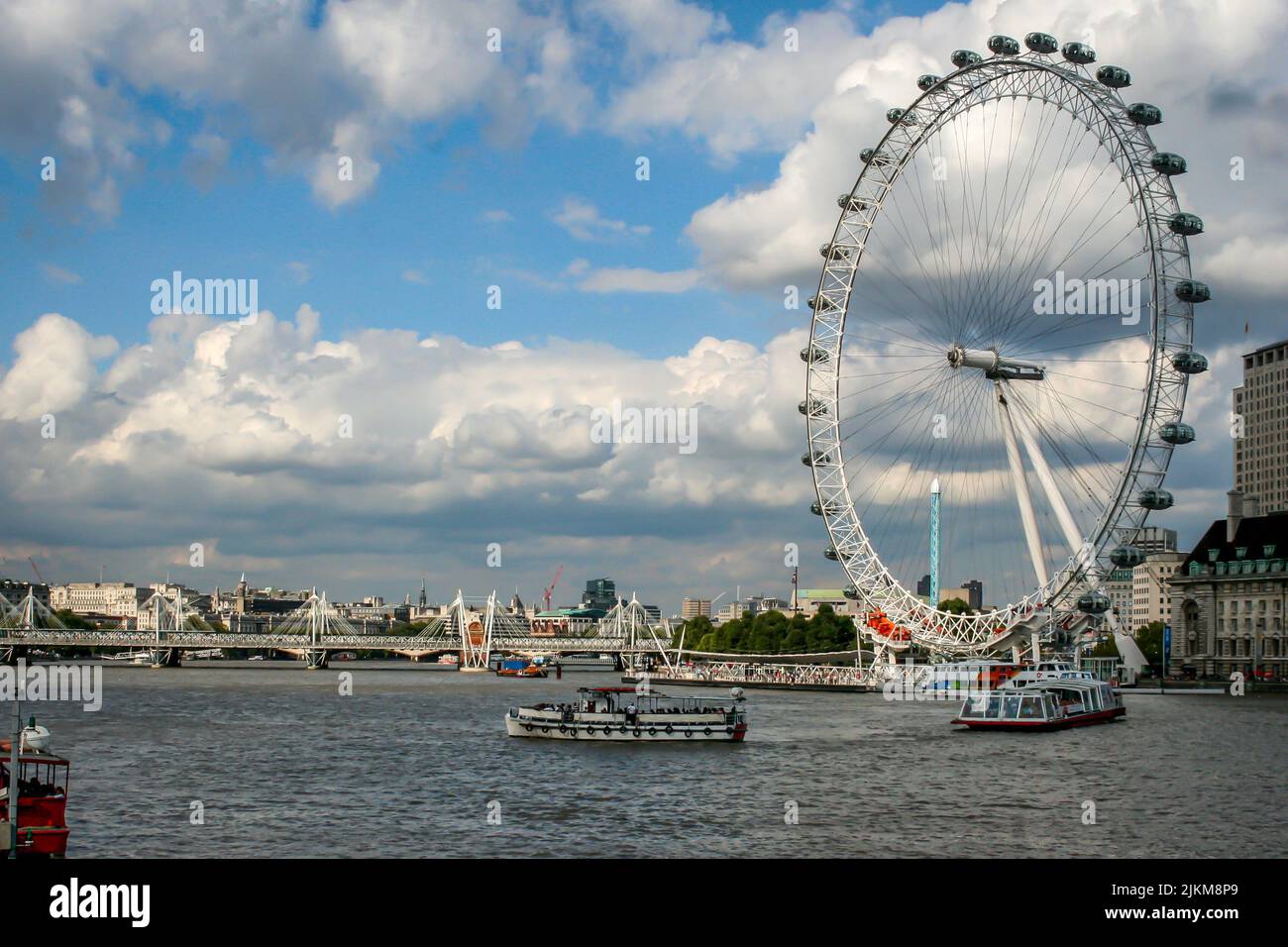 Una hermosa escena de las norias London Eye en Londres, el Reino Unido, con un cielo azul nublado Foto de stock