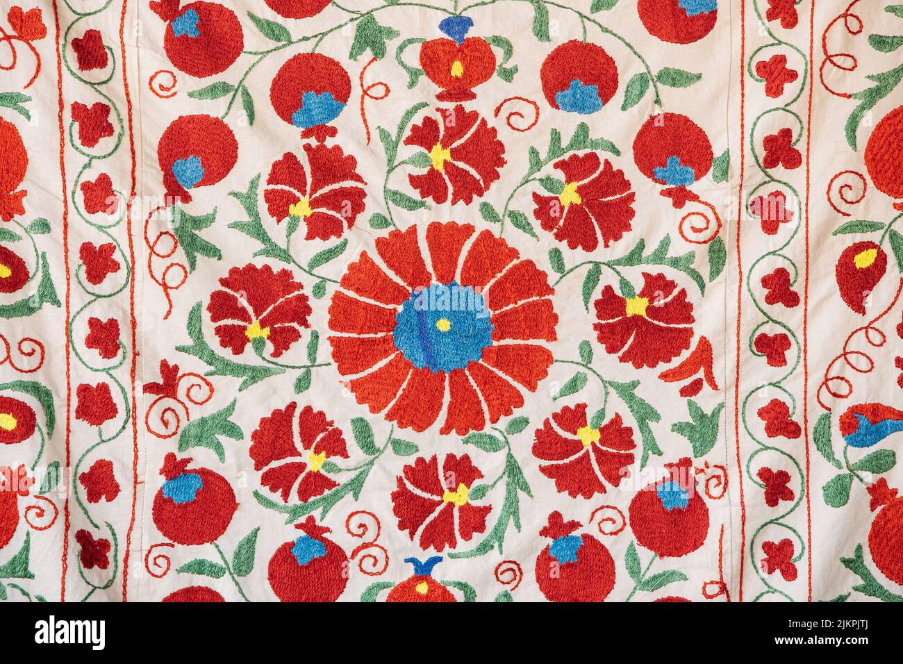 Parte de la textura de la alfombra, ornamento abstracto. Bordado floral tradicional sobre alfombra ligera. Bordado floral de satén hecho a mano. Imagen de primer plano Foto de stock
