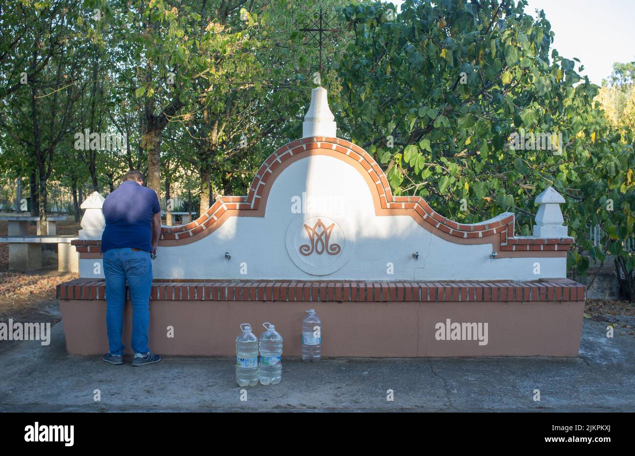 La Codosera, España - 21th de agosto de 2021: Santuario de Nuestra Señora de Chandavila. Hombre local llenando botellas en la fuente santa Foto de stock