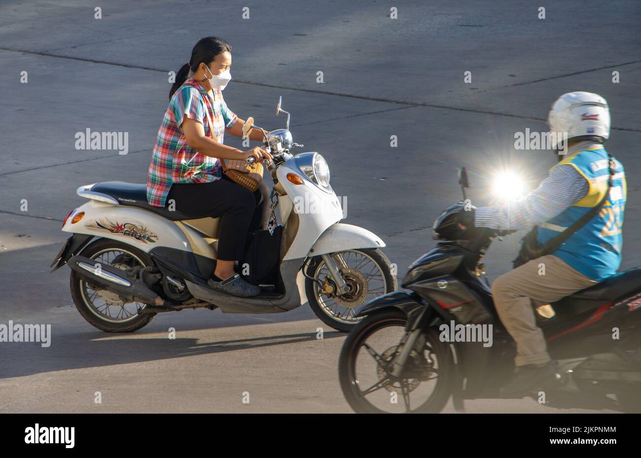 SAMUT PRAKAN, TAILANDIA, MAYO de 26 2022, una mujer con máscara de cara monta una motocicleta Foto de stock