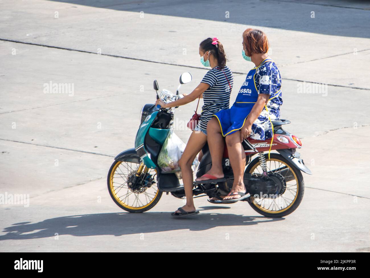SAMUT PRAKAN, TAILANDIA, 30 2022 DE MAYO, dos mujeres viajan en motocicleta en la calle. Foto de stock