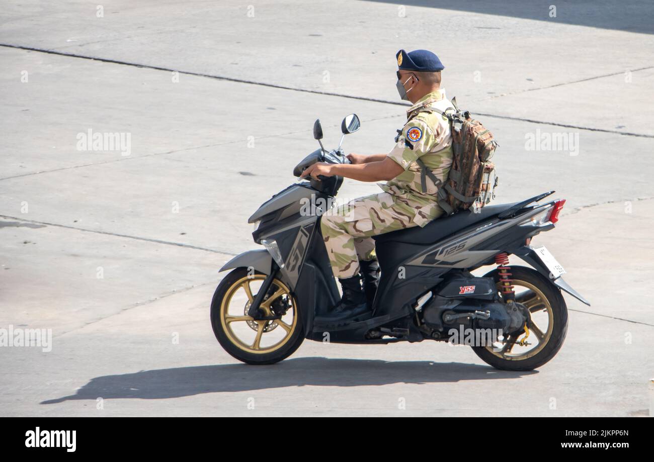 SAMUT PRAKAN, TAILANDIA, 30 2022 DE MAYO, Un hombre con uniforme de camuflaje monta una motocicleta Foto de stock