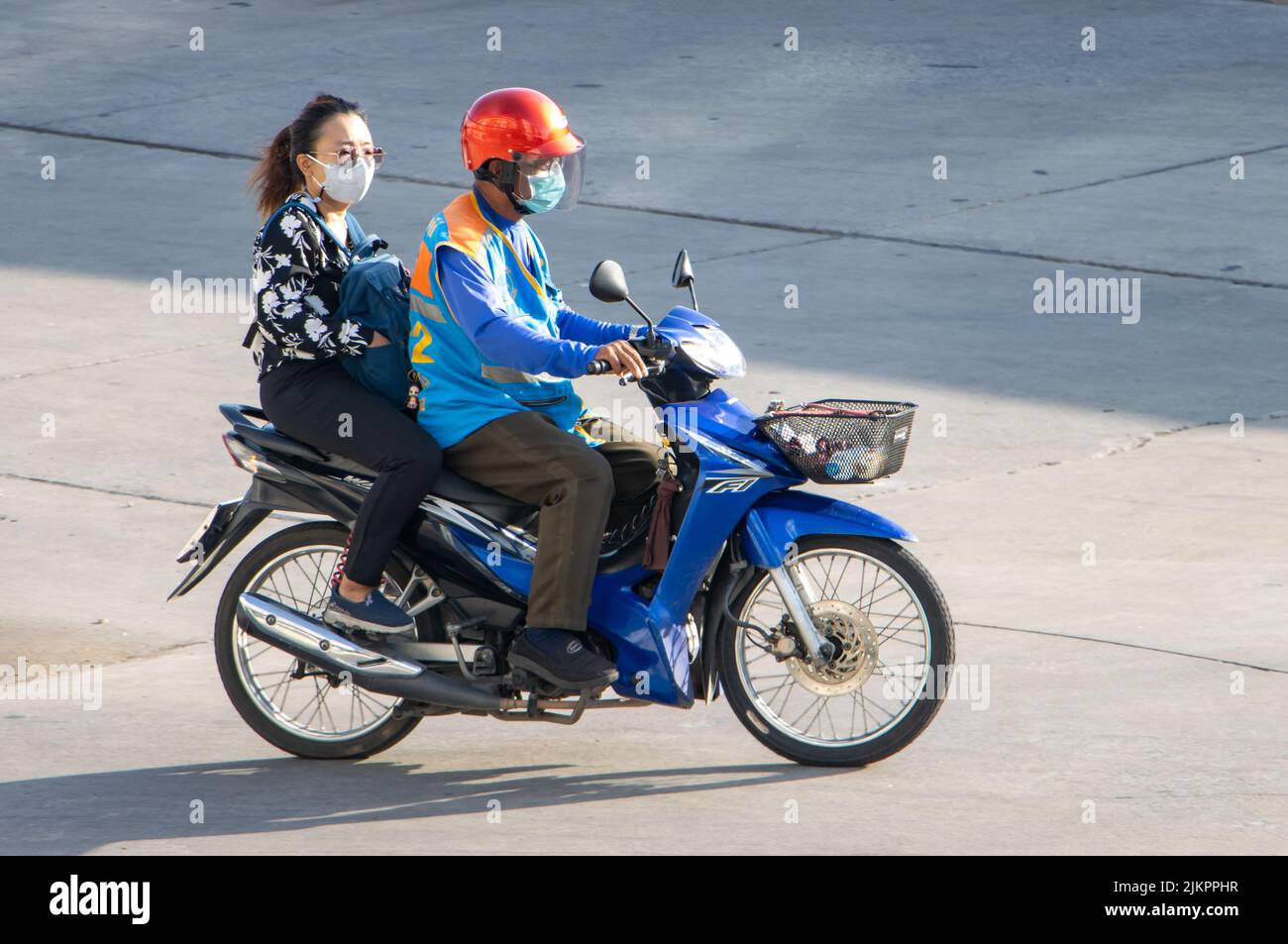 SAMUT PRAKAN, TAILANDIA, 02 2022 DE JUNIO, un taxista viaja en motocicleta con una mujer. Foto de stock