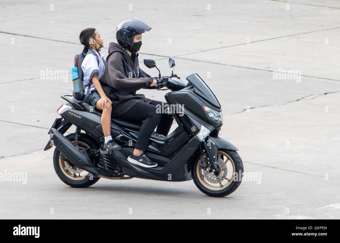 SAMUT PRAKAN, TAILANDIA, JUNIO de 02 2022, Una mujer monta a un niño en una motocicleta. Foto de stock