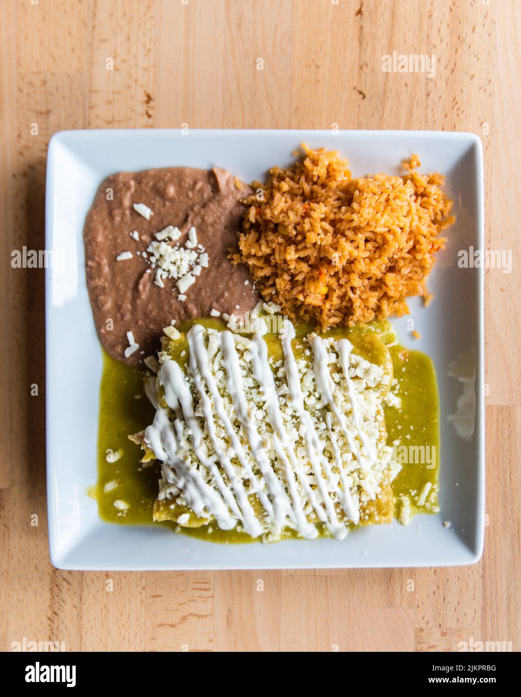 Una toma vertical de un plato mexicano de enchiladas verdes con arroz y