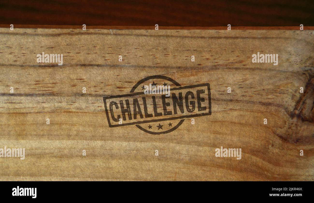 Sello de desafío impreso en una caja de madera. Objetivo lograr, competencia y motivación concepto. Foto de stock