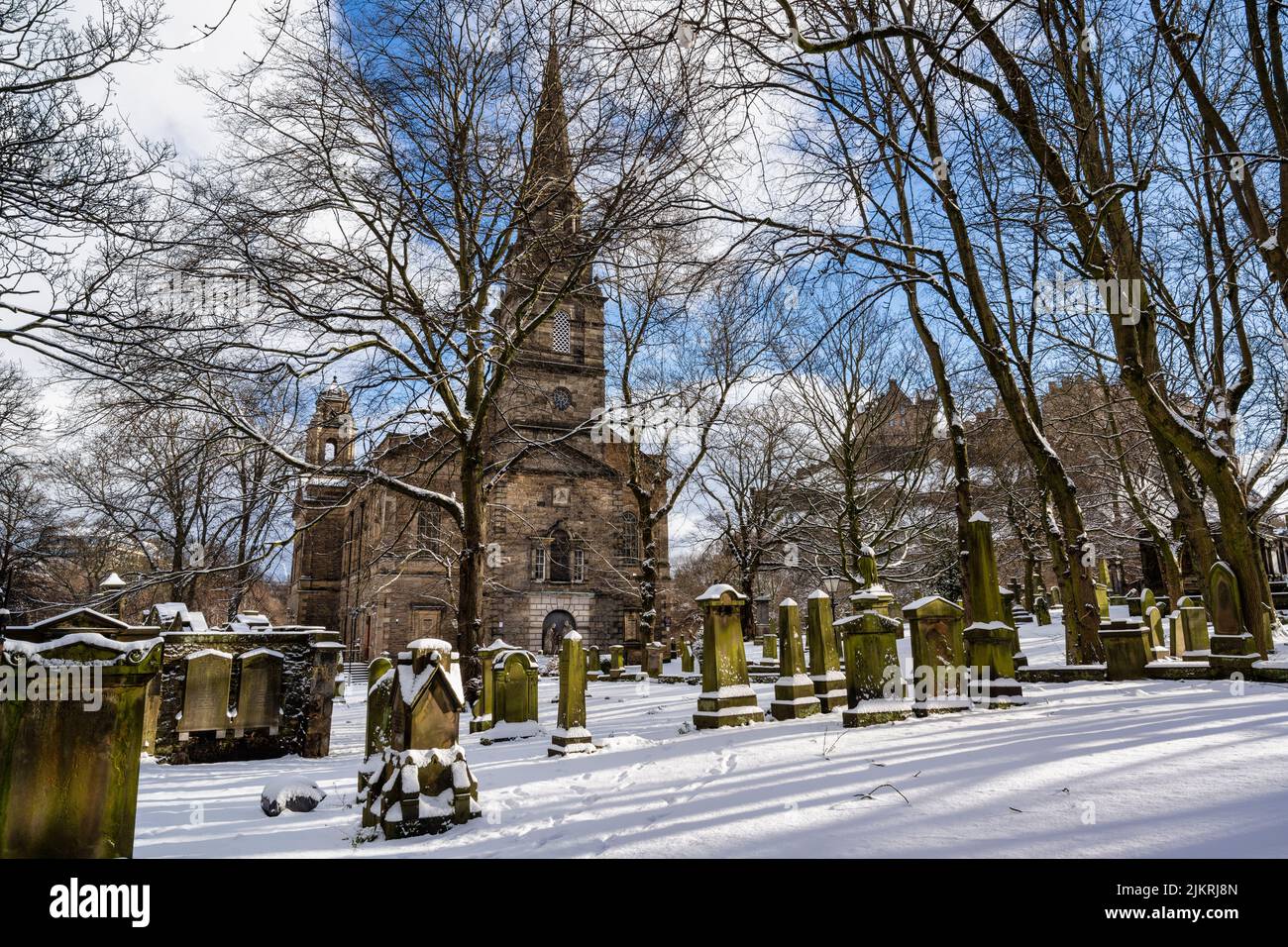 Iglesia Parroquial de St Cuthbert con una alfombra de nieve, con el Castillo de Edimburgo al fondo, en el centro de la ciudad de Edimburgo en Escocia, Reino Unido Foto de stock