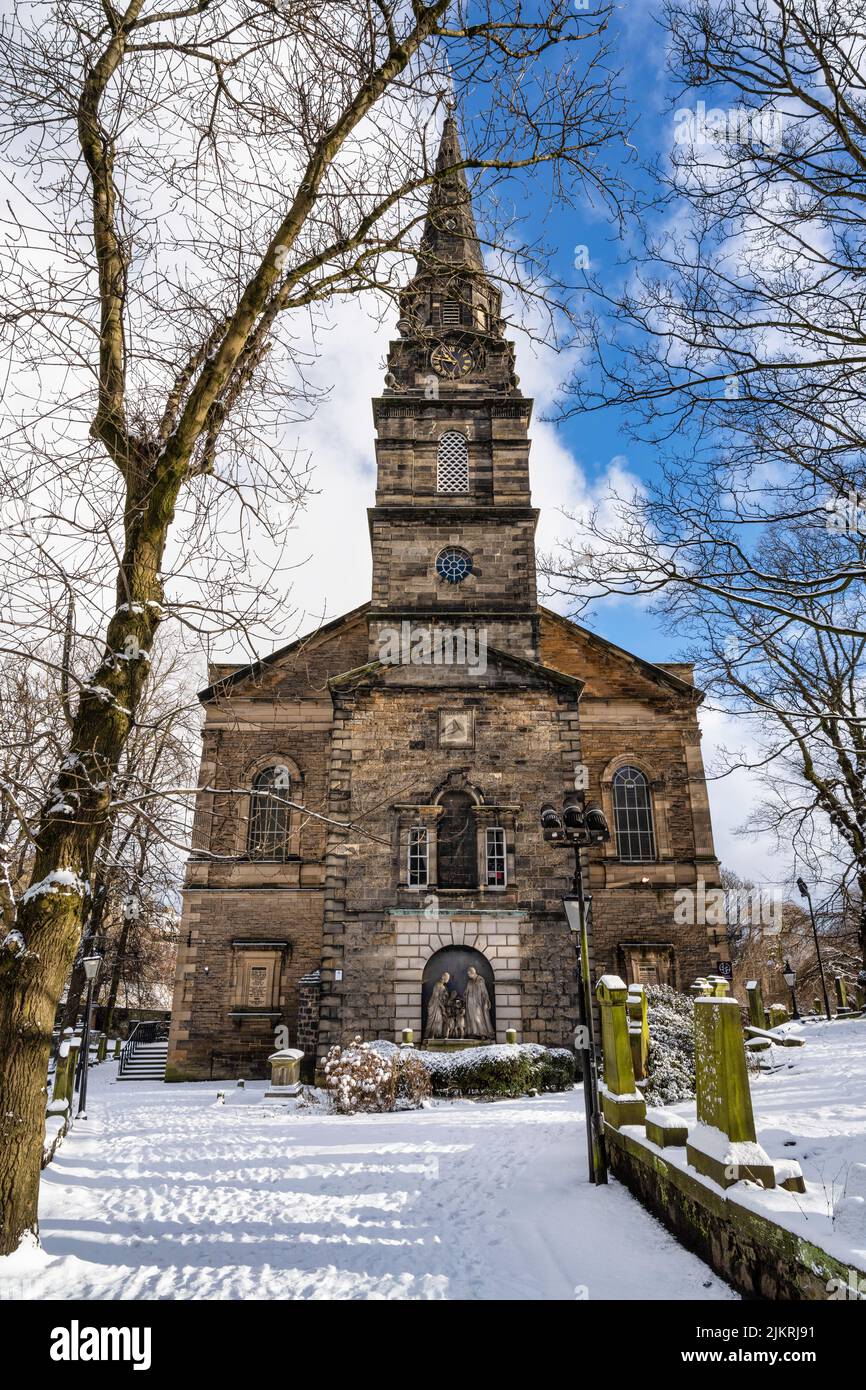 Iglesia Parroquial de St Cuthbert vista a través de un sendero bordeado de árboles con una alfombra de nieve en el centro de la ciudad de Edimburgo en Escocia, Reino Unido Foto de stock