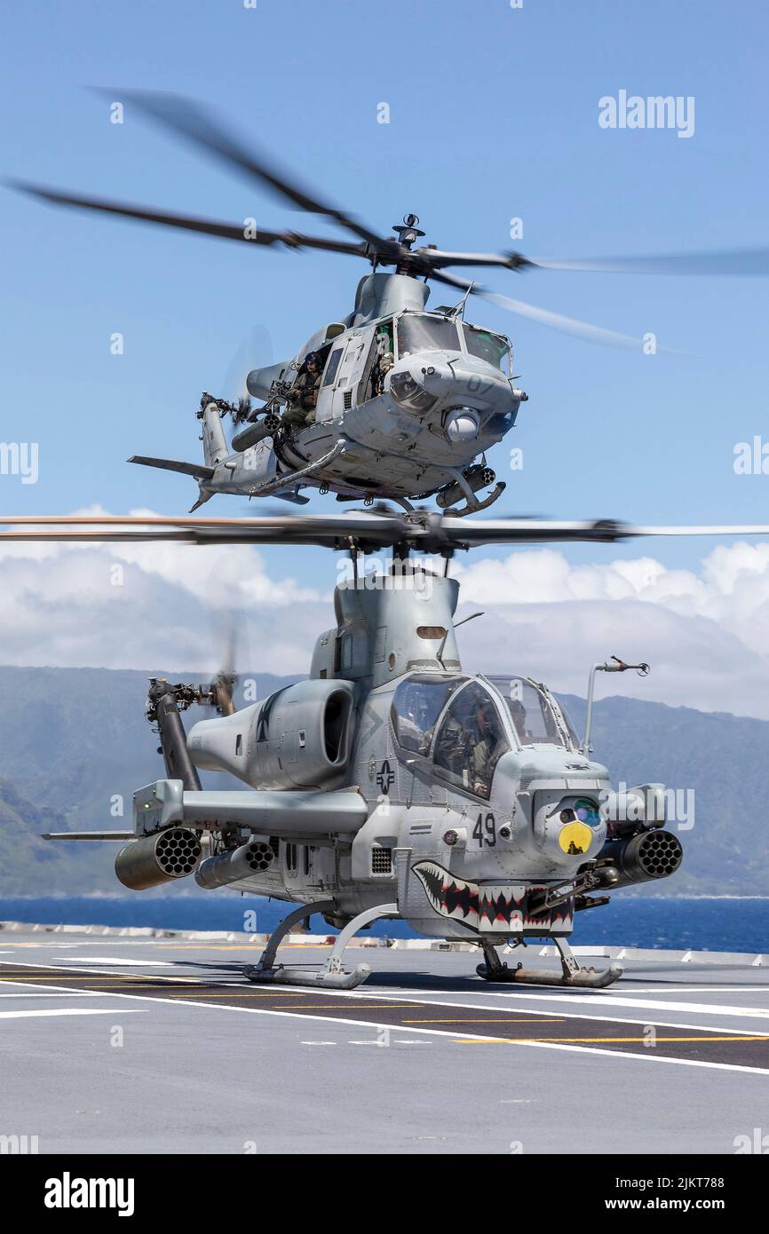 Océano Pacífico, Estados Unidos. 01 de agosto de 2022. Un helicóptero de ataque AH-1Z Viper del Cuerpo de Marines de los Estados Unidos y un helicóptero UH-1Y Venom lanzan desde la cubierta de vuelo del helicóptero de aterrizaje clase Canberra de la Royal Australian Navy durante un asalto anfibio en el ejercicio Rim of the Pacific, el 28 de julio de 2022 frente a la costa de Hawai, EE.UU. Crédito: Marino Matthew Lyall/US Navy/Alamy Live News Foto de stock