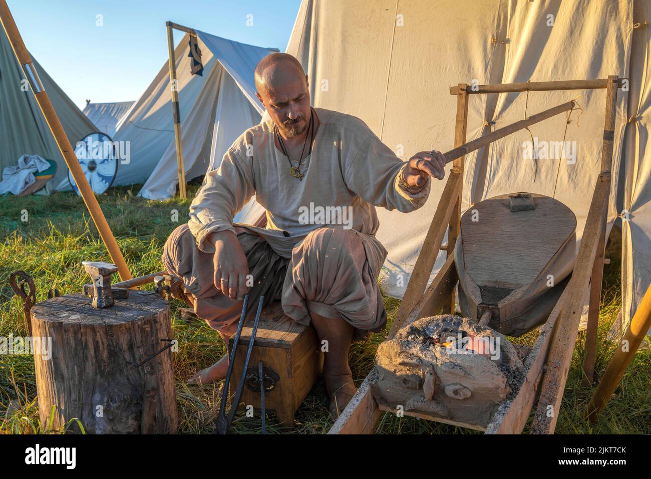 REGIÓN DE TVERSKAYA, RUSIA - 23 DE JULIO de 2022: Un herrero infla la forja de una forja de camping. Histórico campamento del festival 'Epic Coast - 2 Foto de stock