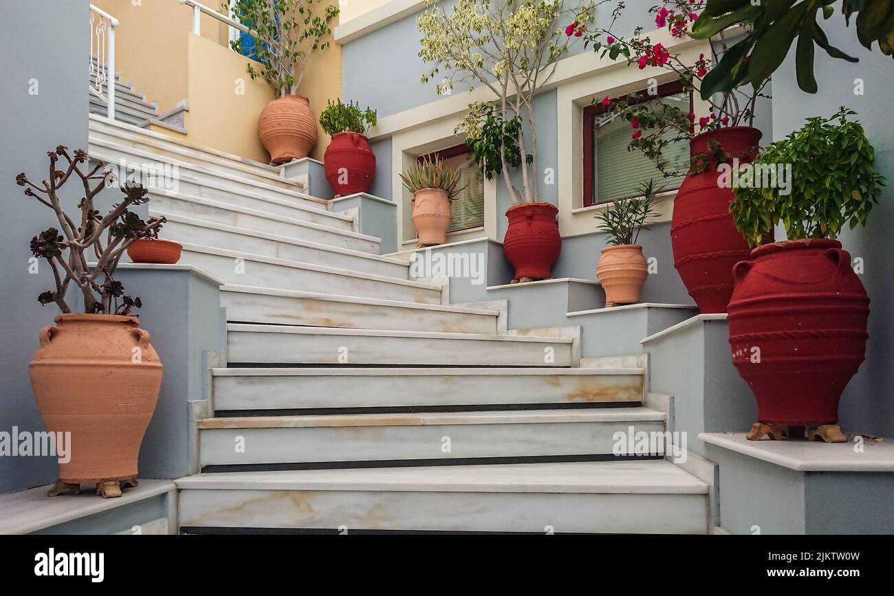 Eine Treppe mit roten Amphoren und Blumen Foto de stock