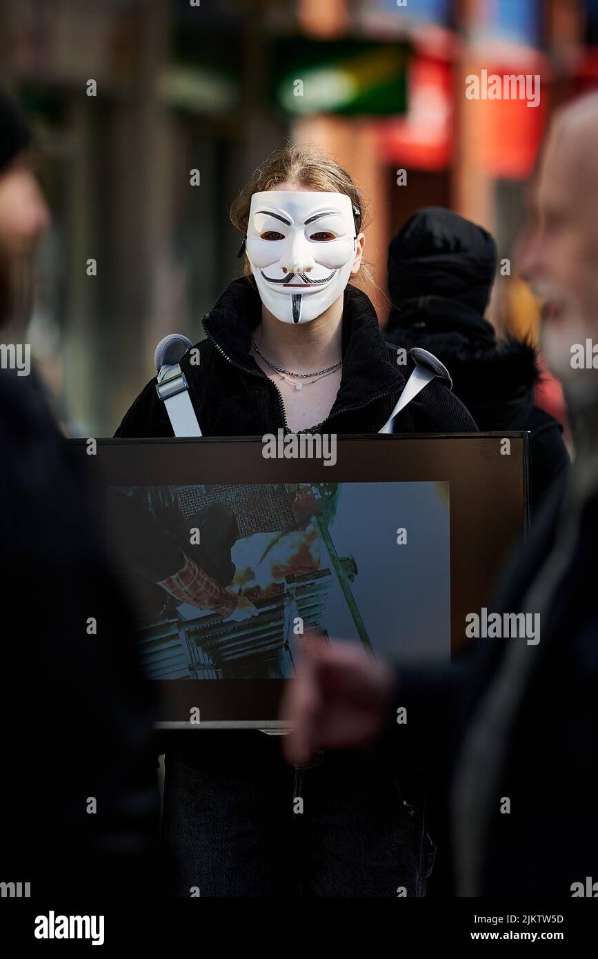 Una activista que llevaba una máscara anónima en las calles de Gran Bretaña Foto de stock