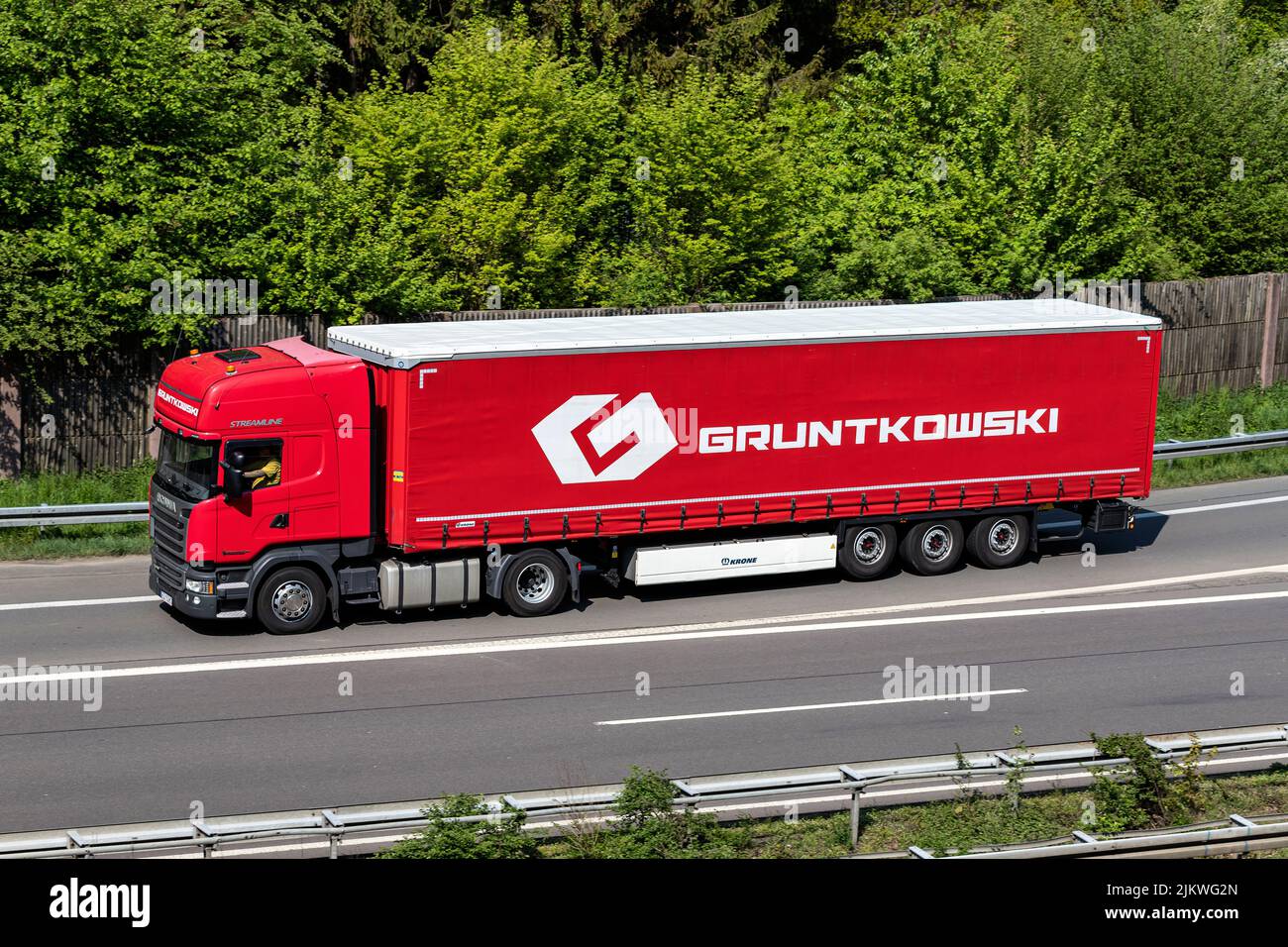Camión Gruntkowski Scania con remolque lateral en autopista Foto de stock