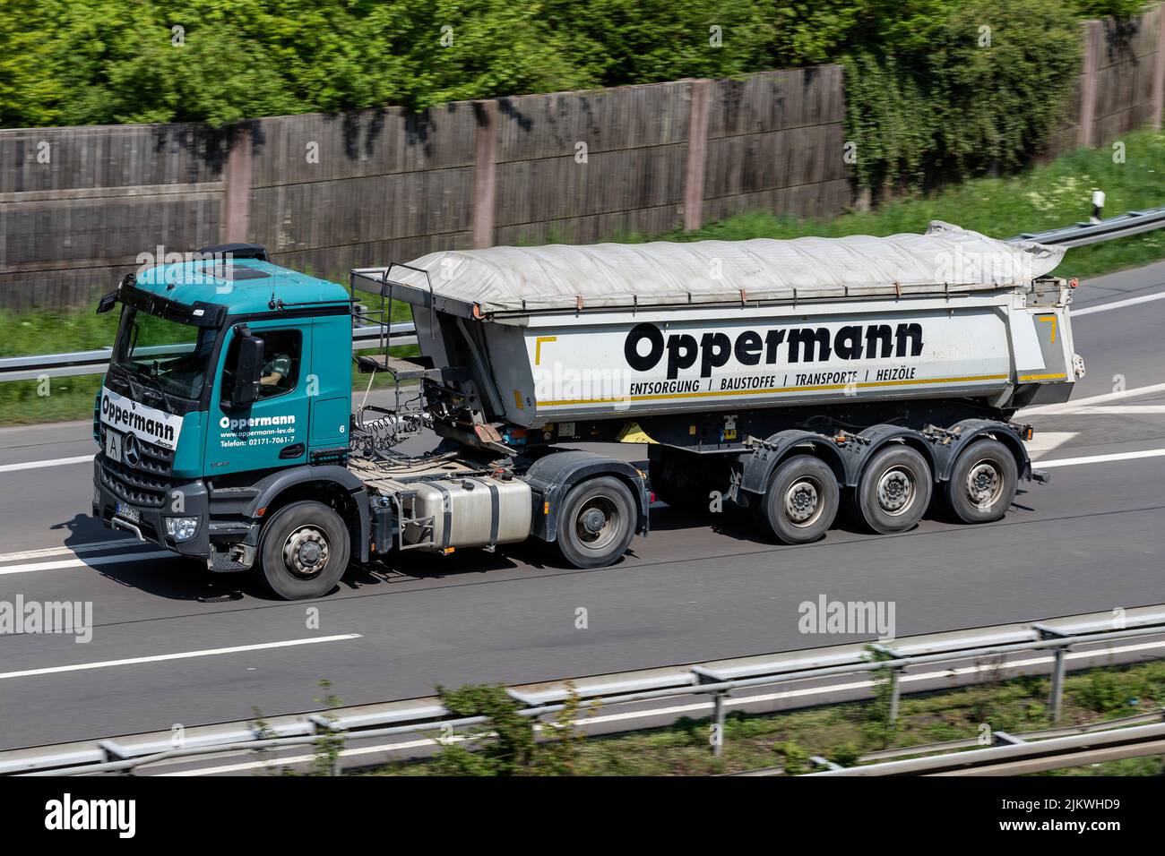 Camión Oppermann Mercedes-Benz Arocs con remolque volquete en autopista Foto de stock