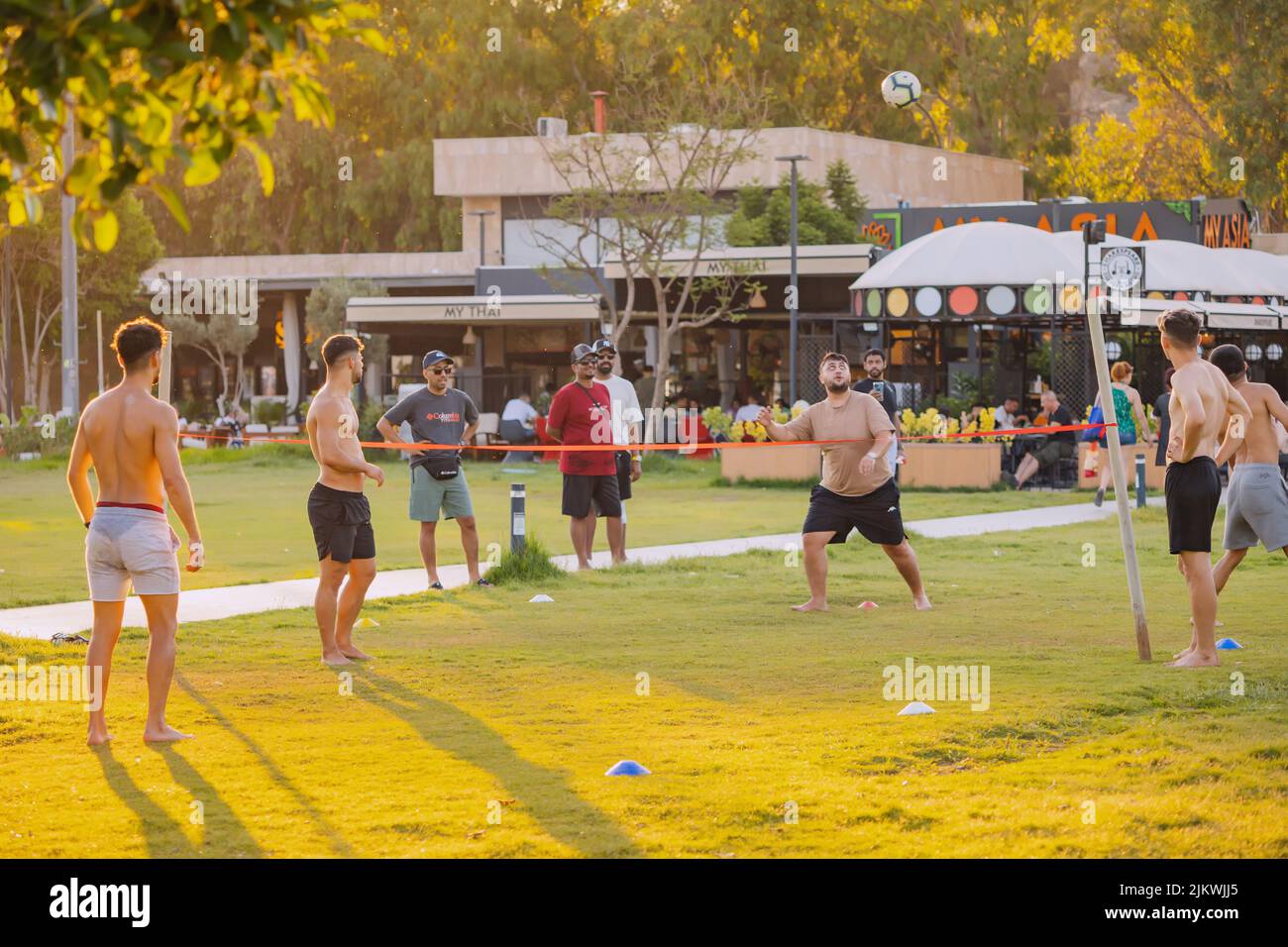 17 de junio de 2022, Antalya, Turquía: La gente se divierte mientras juega al voleibol de pie pateando en una hierba. Deporte malasio del sepaktakraw Foto de stock