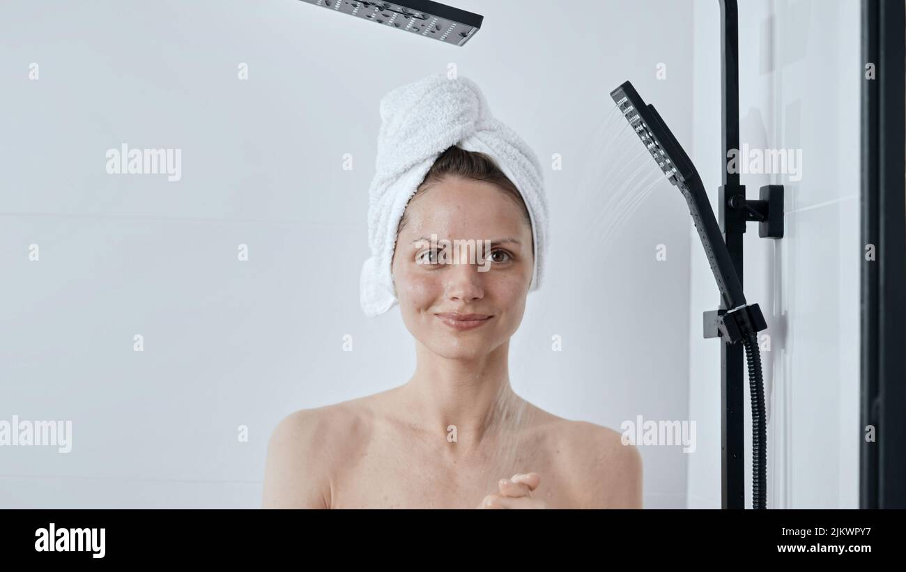 Mujer con toalla en la cabeza saliendo de la ducha con un reloj