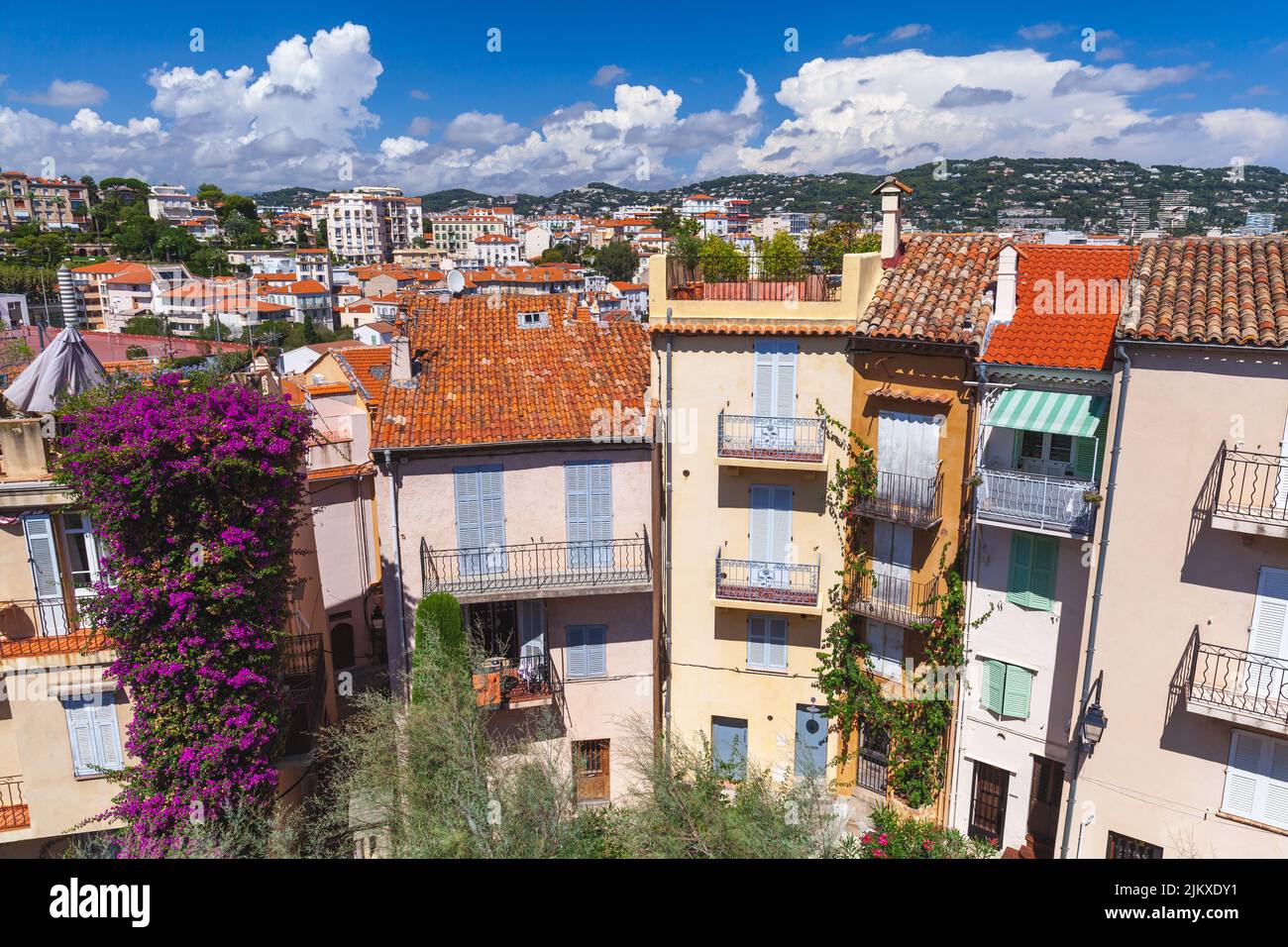Coloridas casas residenciales están bajo cielo nublado en un día soleado. Vista de la calle de Cannes, Francia Foto de stock