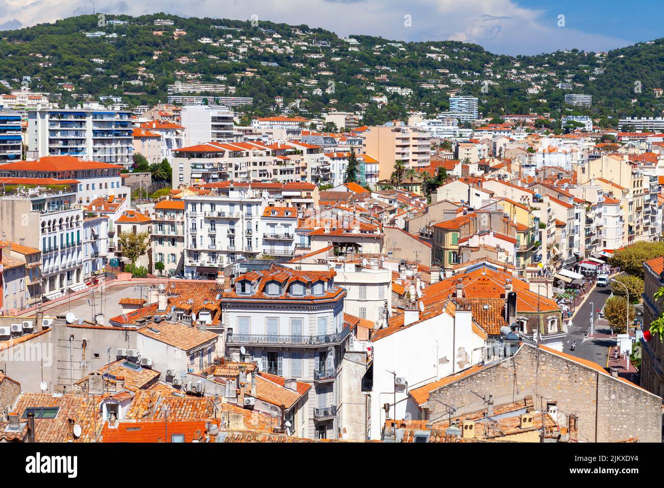 Las casas residenciales con techos de tejas rojas están bajo cielo nublado en un día soleado. Vista aérea del casco antiguo de Cannes, Francia Foto de stock
