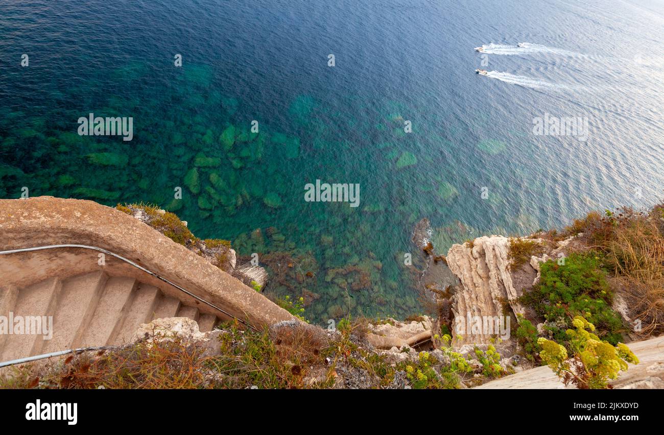 La escalera de piedra baja hasta el mar en una costa rocosa. Bonifacio casco antiguo, Córcega Foto de stock