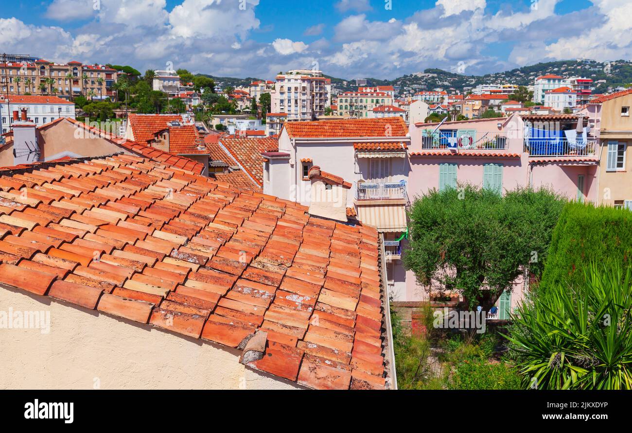 Los techos de tejas rojas están bajo cielo nublado en un día soleado. Vista aérea del casco antiguo de Cannes, Francia Foto de stock