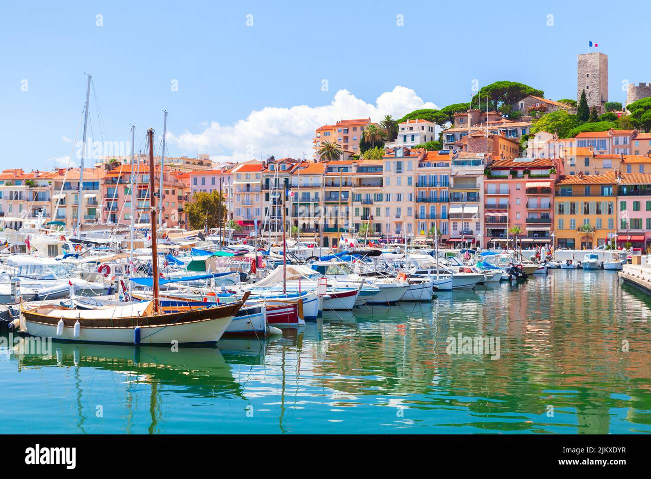 Vista del puerto deportivo de Cannes en un soleado día de verano, paisaje costero con yates amarrados y casas de colores en un fondo. Francia Foto de stock