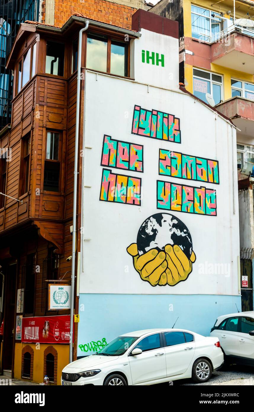 Arte callejero, mural representando globo en las manos con texto 'Bondad en todas partes' en turco, Moda, Kadiköy distrito de Estambul, Turquía Foto de stock