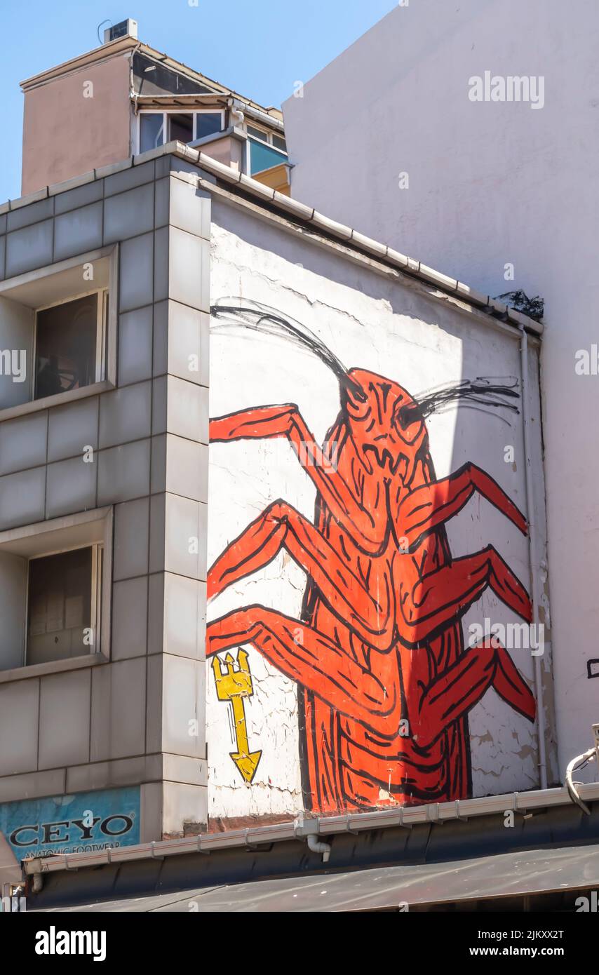 Arte callejero, mural de Canavar que representa cucaracha roja, bicho en la pared en el distrito Kadiköy de Estambul, Turquía Foto de stock