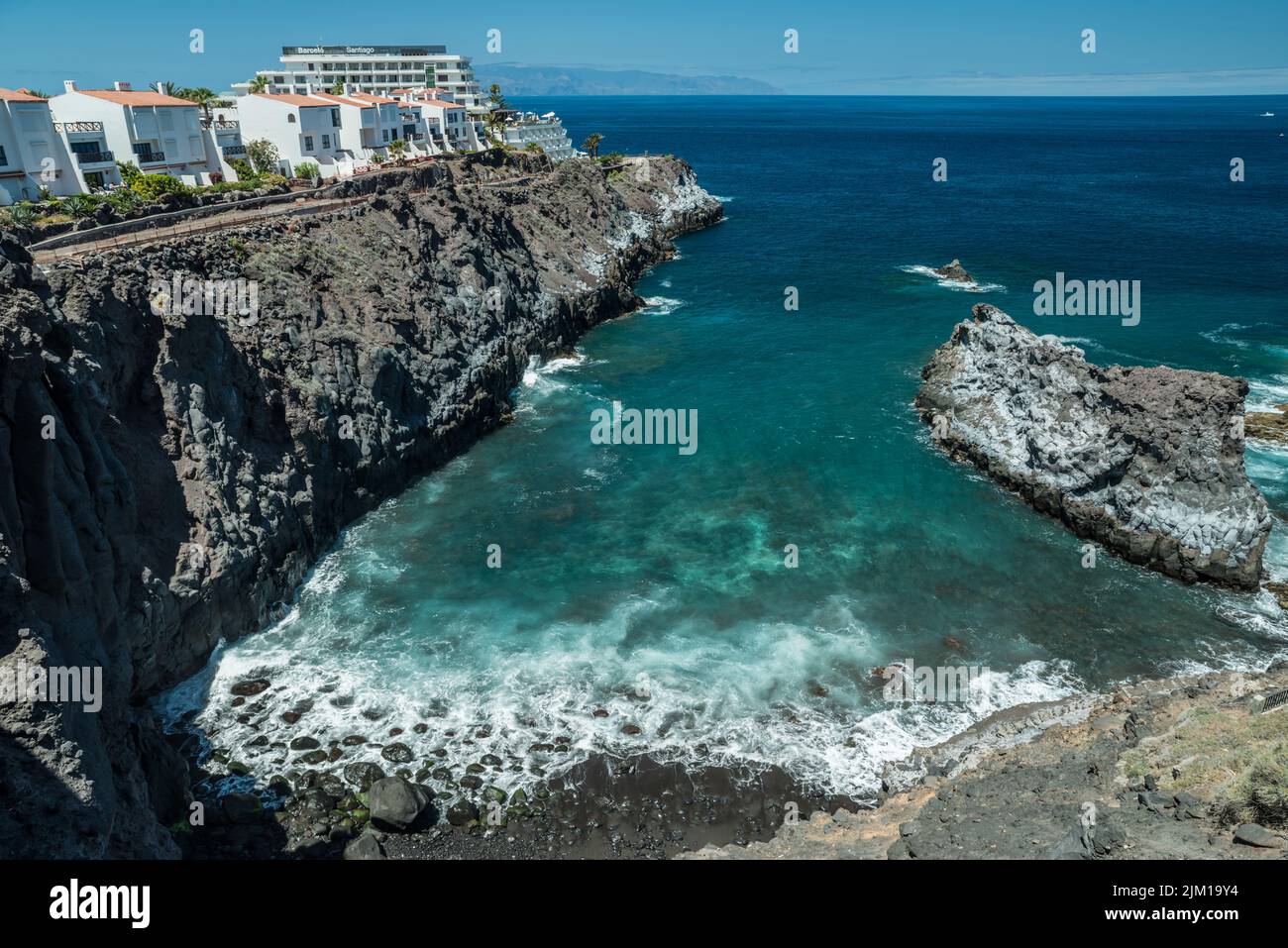 Escarpada y salpicada costa rocosa con increíbles aguas azules de la isla de Tenerife. Foto de stock