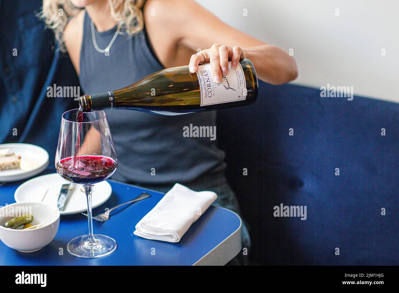 Mujer porporcionando vino tinto en vaso Foto de stock