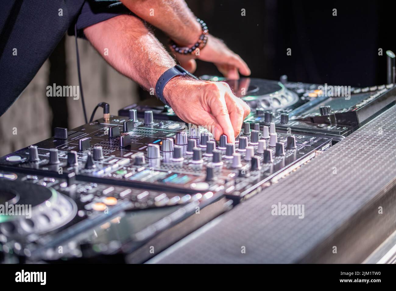 Dj jugando discoteca house progresivo en el concierto de música electro. Manos sobre equipos de DJ Foto de stock
