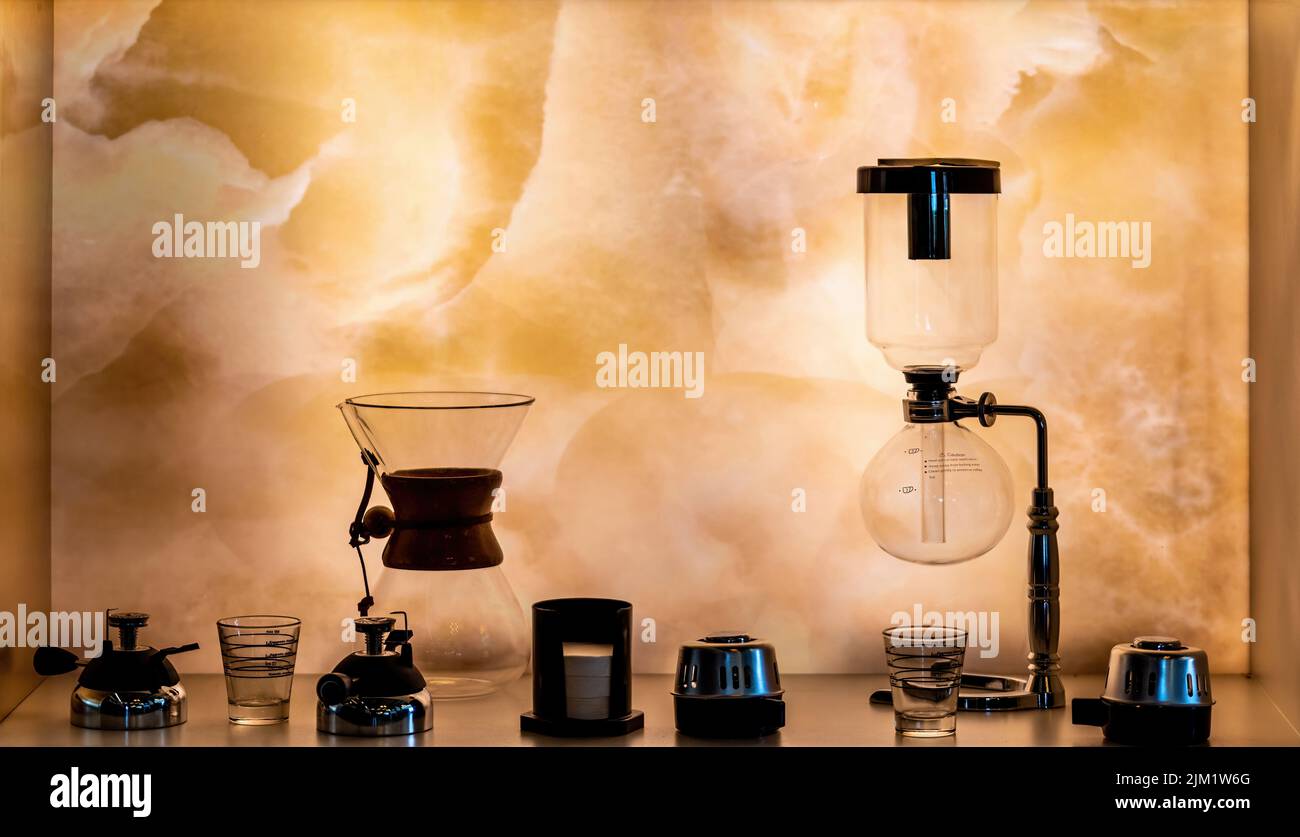 Equipos alternativos de preparación del café de tercera generación sobre el estante iluminado. Enfoque selectivo Foto de stock