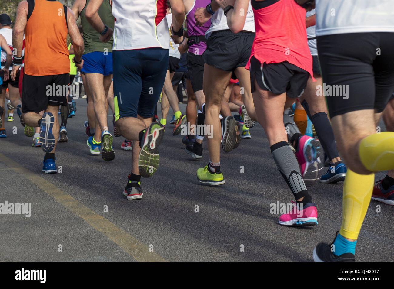 piernas grupo corredores hombres y mujeres correr maratón Foto de stock
