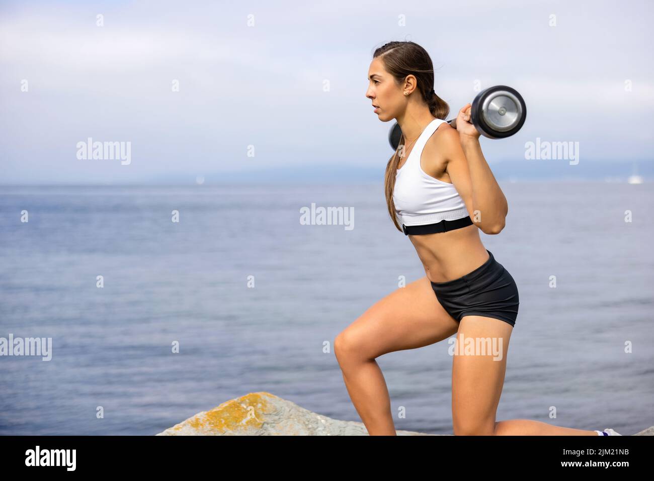 Deportista seguro haciendo ejercicio con Barbell durante el entrenamiento al aire libre Foto de stock
