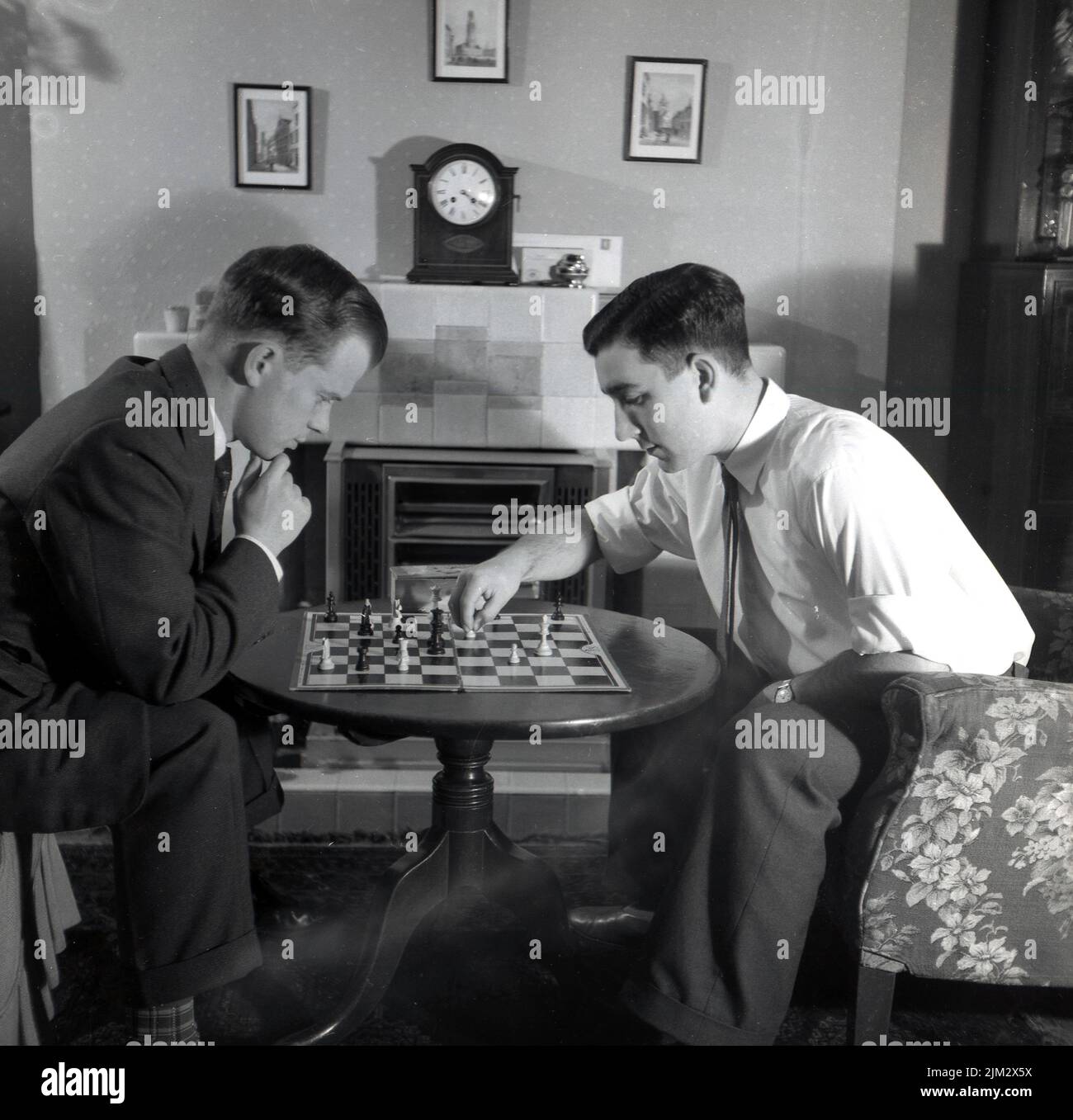1950s, histórico, dos hombres con camisa y corbata, sentados en una pequeña mesa en una sala de ajedrez, Inglaterra, Reino Unido. Foto de stock