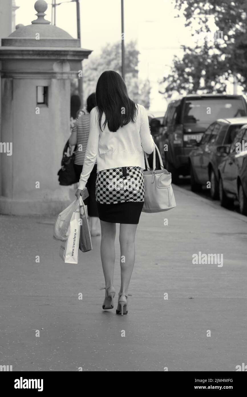 Mujer callejera blanca y negra con bolsas de compras en Belgrado, Serbia Foto de stock