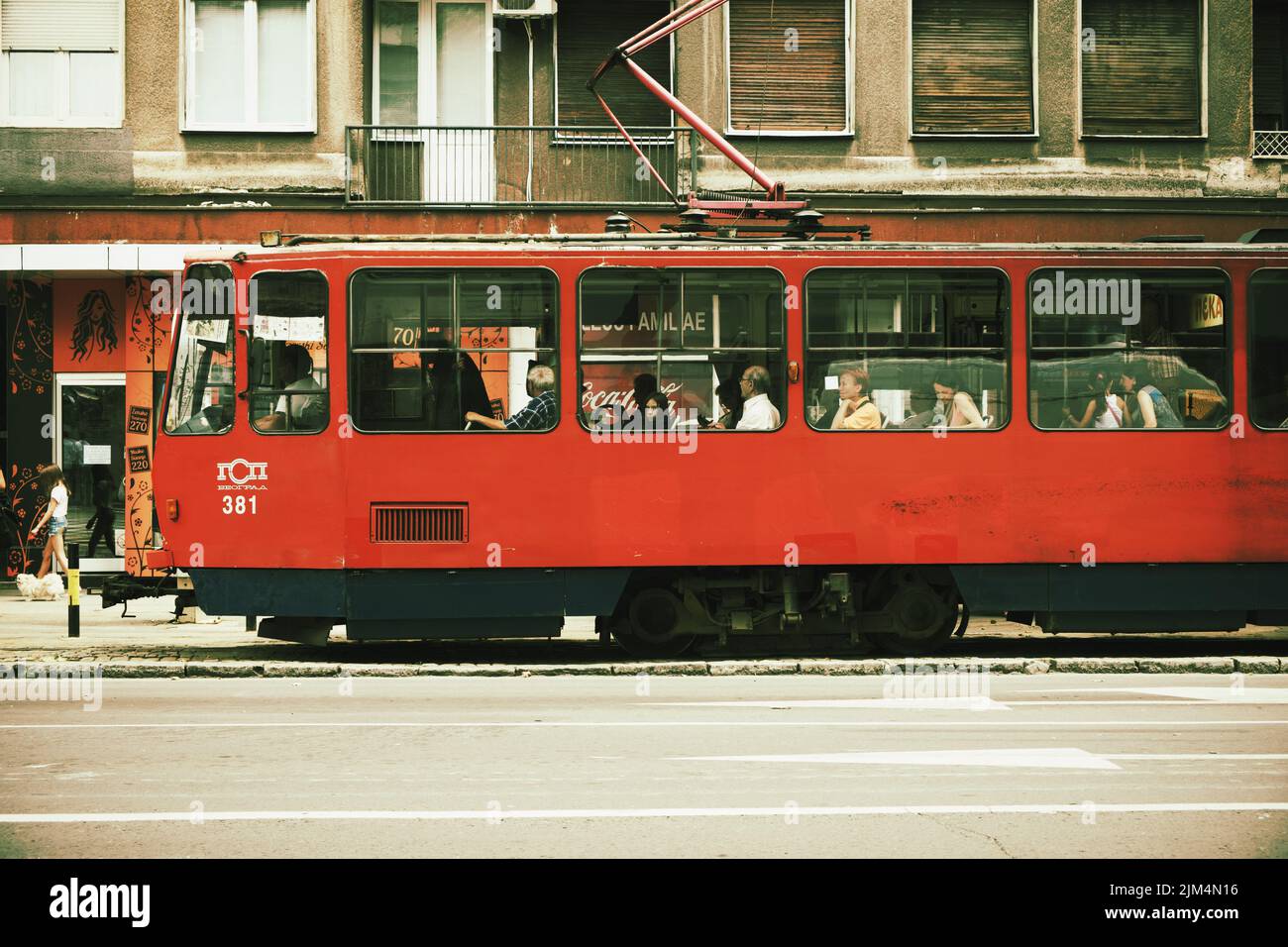 Escena callejera de Belgrado con el antiguo tranvía rojo, Serbia Foto de stock