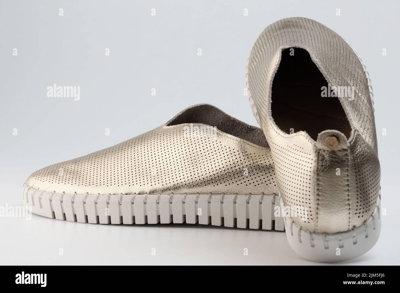 Zapatos informales perforados elegantes de color plateado brillante aislados sobre fondo blanco de estudio Foto de stock
