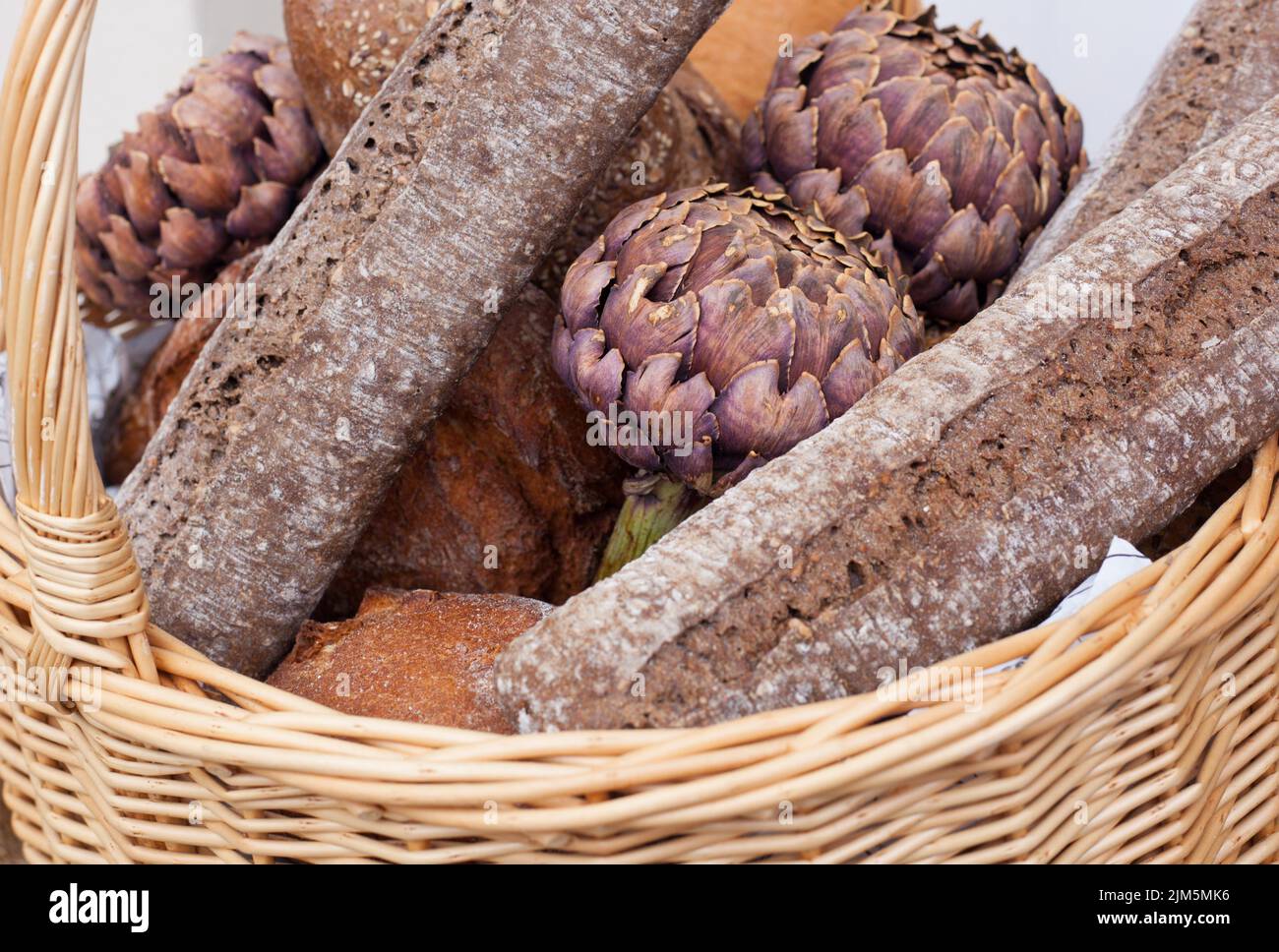 Primer plano de un surtido rústico de pan recién horneado en una cesta de pan. Foto de stock
